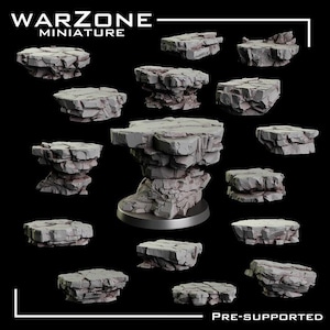 Puede incluir: Colección de formaciones rocosas en miniatura grises, ideales para juegos de mesa o modelismo. La imagen presenta varias formas y tamaños de piezas de terreno pre-soportadas, con el texto "WARZONE MINIATURE" y "PRE-SUPPORTED".