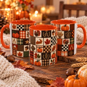 Peut inclure: Trois tasses en céramique avec un intérieur et une anse orange vif, présentant un motif en patchwork de carrés sur le thème de l'automne. Le design inclut des illustrations de citrouilles, dindes, feuilles d'érable, glands et tartes.