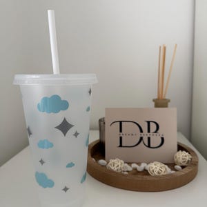May include: A white ceramic mug with a black handle and the text "But First, Coffee" in a bold, black font. The mug is set against a neutral background, highlighting its simple design.