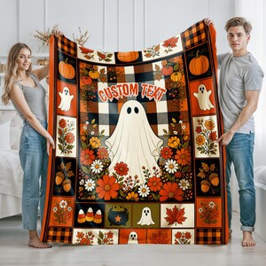 May include: A rectangular throw blanket featuring a central white ghost, the text CUSTOM TEXT, and a black and orange buffalo plaid background. The border includes illustrations of pumpkins, ghosts, autumn flowers, acorns, and a cauldron.