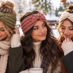 May include: Three knitted headbands featuring a twisted front design. One headband is olive green, one is dusty rose, and one is cream. Each piece is crafted with a ribbed texture and is worn around the head to cover the ears for warmth.