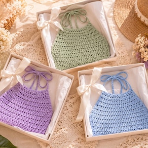 Puede incluir: Tres tops halter de ganchillo hechos a mano en cajas de regalo. Los tops son de colores pastel: lavanda, verde claro y azul claro. Cada top se presenta en una caja blanca con una cinta blanca atada con un lazo.