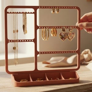 May include: Terracotta-colored jewelry organizer with multiple compartments and a tray. The organizer holds various gold necklaces, earrings, and rings. The word "Terracotta" is written in script at the bottom left.