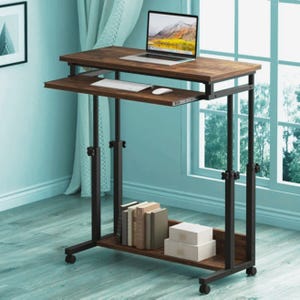 May include: A brown and black adjustable laptop desk with a keyboard tray and a lower shelf. A laptop, keyboard, and mouse are on the desk. The desk has a metal frame and is on wheels.