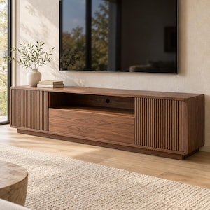 Peut inclure: Un long meuble TV rectangulaire en bois foncé doté de deux placards latéraux à portes verticales rainurées, d'une étagère centrale ouverte et d'un tiroir inférieur. Le meuble présente des coins arrondis et repose sur une base basse.