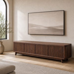 May include: A long, rectangular dark brown wooden media console featuring four cabinet doors with vertical fluted detailing. The console is supported by short, tapered legs and has rounded corners, providing a sleek, low-profile storage solution.