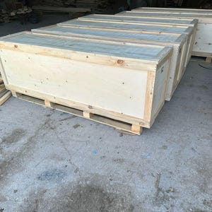 K&ouml;nnte beinhalten: Eine Reihe rechteckiger h&ouml;lzerner Transportkisten aus hellem Sperrholz und massivem Holzrahmen. Jede Kiste ist auf einer Holzpalette montiert und verf&uuml;gt &uuml;ber eine flache Oberseite sowie vertikale Seitenw&auml;nde mit sichtbarer Maserung.