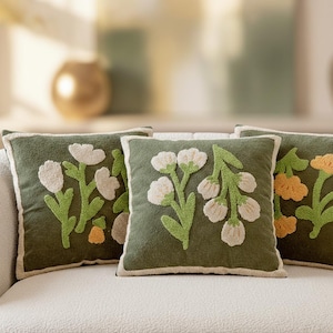 May include: A trio of ceramic mugs with a speckled, matte finish in cream, light brown, and dark brown. Each mug features a minimalist design and a rounded handle. Suitable for tea or coffee, these mugs offer a simple, understated aesthetic.