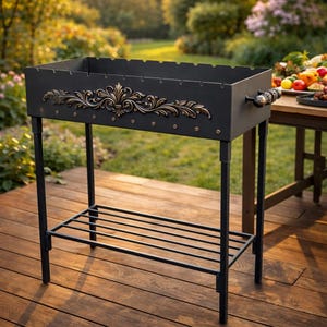 Pode incluir: Uma grelha de churrasco de metal preto com um design floral decorativo em bronze. A grelha tem uma caixa de fogo retangular, uma prateleira inferior e quatro pernas. A pega é feita de madeira e metal. Projetada para cozinhar ao ar livre.