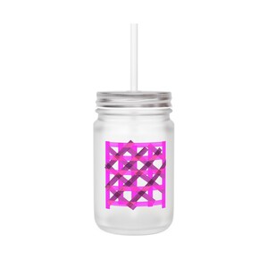 Op de afbeelding: Een heldere glazen mason jar met een zilveren deksel en een wit rietje. De pot heeft een roze en paars geruit ontwerp op de voorkant. Het ontwerp bestaat uit elkaar kruisende lijnen in verschillende tinten roze en paars.