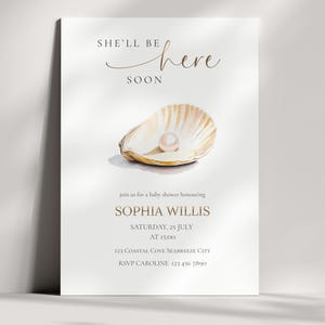 Könnte beinhalten: Babyparty-Einladung mit einer Illustration einer Muschel und einer Perle. Der Text lautet "She'll be here soon" und enthält Details für Sophias Babyparty: Datum, Uhrzeit und Ort.