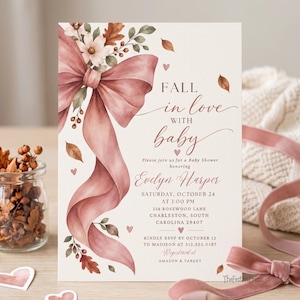 Puede incluir: Una tarjeta de invitación rectangular para baby shower con un gran lazo rosa empolvado, flores blancas y hojas de otoño. El texto dice: Fall in love with baby, please join us for a Baby Shower honoring Evelyn Harper, Saturday, October 24.
