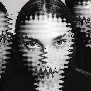 May include: Black and white portrait of a person with dark hair and eyes. The image has a wave-like distortion effect across the face, creating a unique visual texture. The focus is on the eyes, which appear to be looking directly at the viewer.
