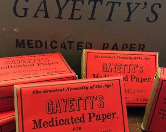May include: Several rectangular packages of Gayetty's Medicated Paper for the water-closet, featuring bright red wrappers with black text that reads The Greatest Necessity of the Age, Gayetty's Medicated Paper, for the water-closet, Est'd 1857.