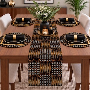 May include: A rectangular table runner featuring a black background with a repeating pattern of gold diamond shapes and small white dots. The runner is centered on a wooden table with four round black placemats, black napkins, and gold napkin rings.