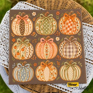 Op de afbeelding: Een vierkant bruin bord met een raster van negen decoratieve pompoenen, elk versierd met een strik. De pompoenen tonen diverse patronen waaronder luipaardprint, gingham, stippen en bloemmotieven in tinten oranje, groen en beige.