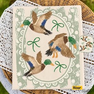 May include: A rectangular canvas print featuring three mallard ducks in flight, painted in brown, green, and blue. The ducks are arranged within a sage green scalloped oval frame decorated with white polka dots and small green ribbon bows.