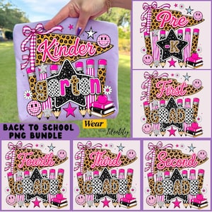 May include: A light purple t-shirt featuring a school-themed graphic with a leopard print pennant, a black star, pink and leopard print pencils, a stack of books, and smiley faces. The text reads Kinder, garten, Pre-K, First, Second, Third, and Fourth Grade.