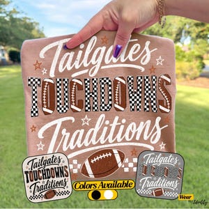 May include: A tan t-shirt featuring the white text Tailgates, the word TOUCHDOWNS in a black and white checkered pattern with football shapes, and the white text Traditions. The design includes small stars and a brown football graphic.