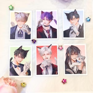 May include: A collection of six art prints showcasing anime-style illustrations of male characters with cat ears. The characters are dressed in formal wear, with diverse hair colours and expressions. The prints are displayed on a white surface with decorative elements.