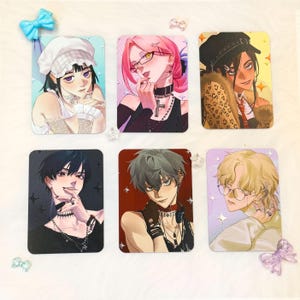 May include: Six rectangular art prints featuring anime-style illustrations of characters with various hairstyles, accessories, and expressions. The prints have a soft, colorful aesthetic, with a light background and decorative accents.