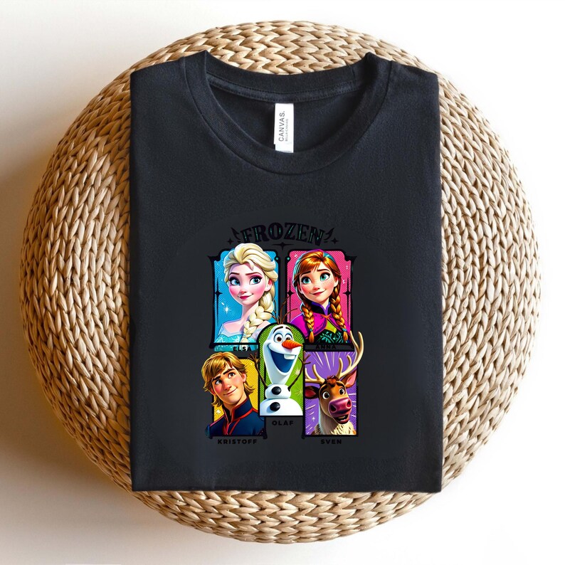 May include: Black t-shirt featuring the word "FROZEN" above a graphic of characters from the movie, including Elsa, Anna, Olaf, Kristoff, and Sven. The shirt is made of a soft material and is suitable for casual wear.