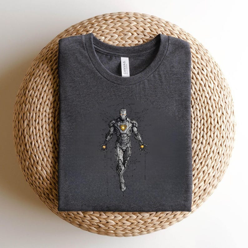 Op de afbeelding: Donkergrijs t-shirt met een gedetailleerde illustratie van Iron Man. Het ontwerp toont het pantser van het personage met een gloeiende boogreactor en repulsorstralen. Het shirt is gemaakt van zacht materiaal en heeft een klassieke ronde hals.
