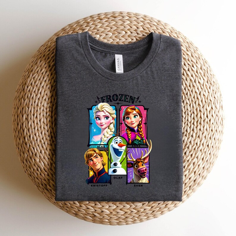 May include: Dark gray t-shirt featuring the word "FROZEN" above a graphic of characters from the movie, including Elsa, Anna, Olaf, Kristoff, and Sven. The shirt is made of a soft material and is suitable for casual wear.