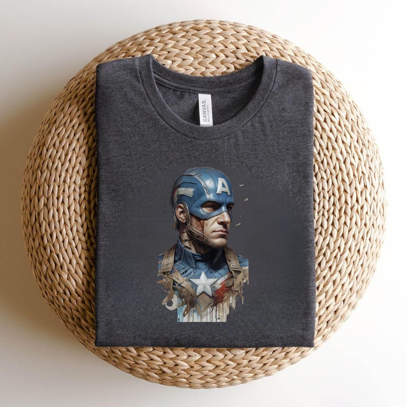 May include: Dark gray t-shirt featuring a Captain America graphic. The graphic depicts Captain America in his iconic blue and white costume, with a blue helmet and the letter "A" on the forehead. The shirt is made of a soft material.