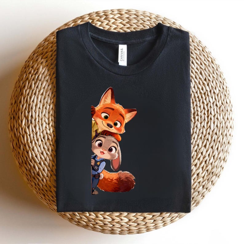 May include: A black crew neck t-shirt featuring a graphic print of a cartoon fox and a cartoon rabbit peeking out from the side. The fox is orange with large ears, and the rabbit is gray with a blue uniform, both rendered in a colorful style.