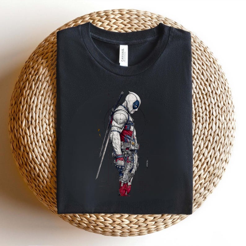 Puede incluir: Una camiseta negra con una ilustraci&oacute;n gr&aacute;fica de un personaje enmascarado con un traje blanco, rojo y azul. El personaje aparece de perfil, llevando una espada larga en la espalda, con l&iacute;neas detalladas y una paleta de colores sobria.