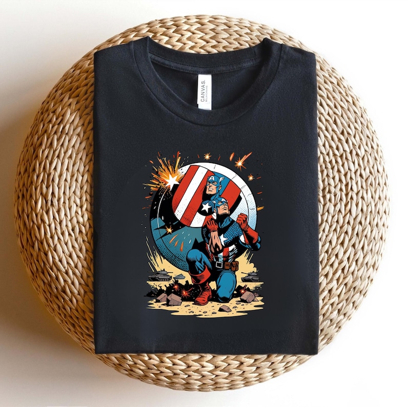 Puede incluir: Camiseta negra con un gr&aacute;fico de Capit&aacute;n Am&eacute;rica en acci&oacute;n. La ilustraci&oacute;n muestra al Capit&aacute;n Am&eacute;rica arrodillado con su escudo. El escudo es rojo, blanco y azul, con una estrella. El dise&ntilde;o es de estilo c&oacute;mic.
