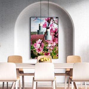 Puede incluir: Un comedor con una mesa y sillas de madera clara. Una impresión floral enmarcada con flores rosas cuelga de la pared. Dos lámparas colgantes cuelgan sobre la mesa. Jarrones decorativos y hierba de la pampa completan la decoración.