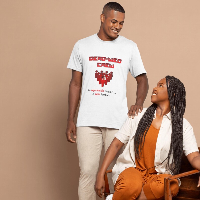 May include: A white t-shirt with the text "DEAD-LIZED CREW" in red block letters and a red graphic of people. Below the graphic, the text reads "La negociaci&oacute;n empieza... el caos tambi&eacute;n."