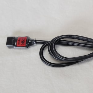 May include: Black USB Type-C to USB Type-C charging cable. The cable has a black connector on one end with a red label and a right-angle connector on the other end. The text "USB Type-C" is displayed below the USB icons.