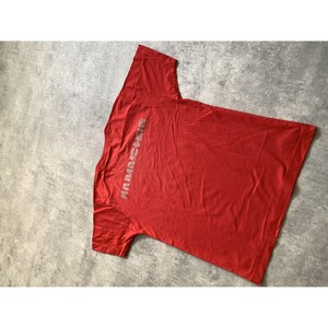 Peut inclure: Un t-shirt rouge &agrave; manches courtes avec le mot Rammstein imprim&eacute; en lettres majuscules gris clair, dispos&eacute;es verticalement sur le c&ocirc;t&eacute; gauche de la poitrine. Le v&ecirc;tement est compos&eacute; d'un tissu rouge uni avec un col rond et un ourlet standard.