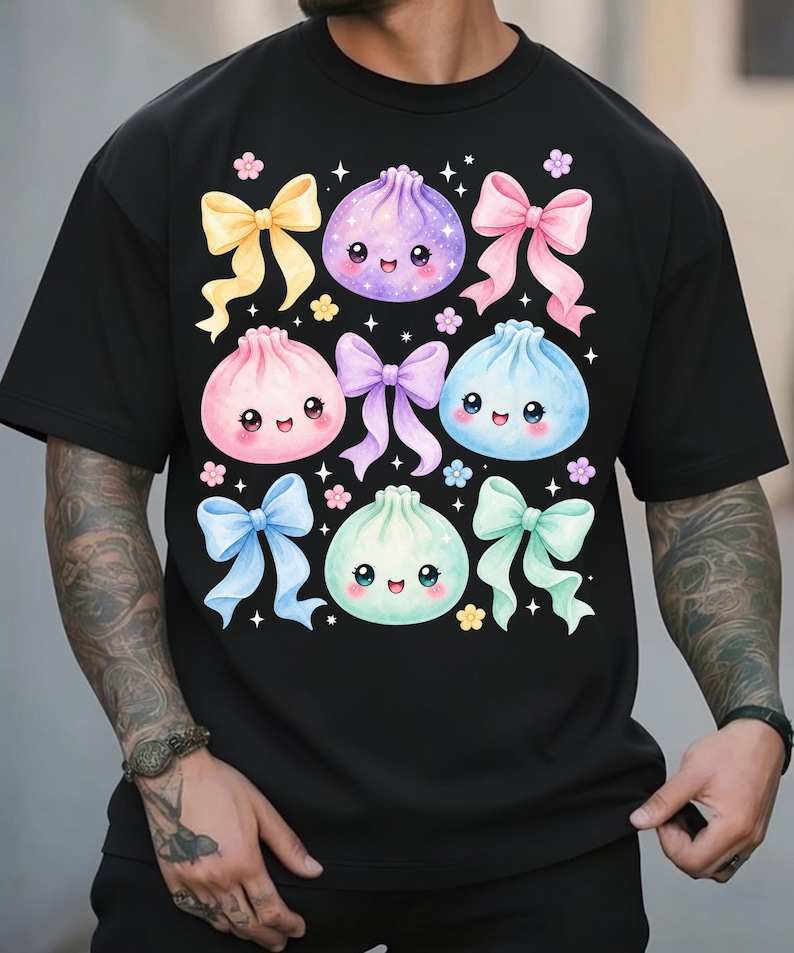 May include: A black short-sleeved t-shirt featuring a graphic print of four pastel-colored, smiling dumpling characters in purple, pink, blue, and mint green, interspersed with various colored ribbons and small flower accents.