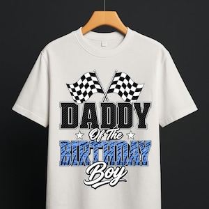 Peut inclure: Un t-shirt blanc à manches courtes avec une impression graphique représentant deux drapeaux de course à damier en haut. Sous les drapeaux, le texte indique DADDY Of The BIRTHDAY Boy, avec le mot BIRTHDAY en motif de bande de roulement bleu.