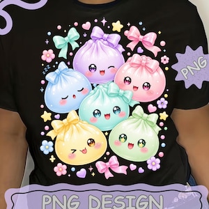 May include: A black t-shirt featuring a graphic print of six colorful, round, cartoon-style dumplings with faces, each adorned with a bow. The design includes small stars, hearts, and flowers scattered around the dumplings, with the text PNG DESIGN.