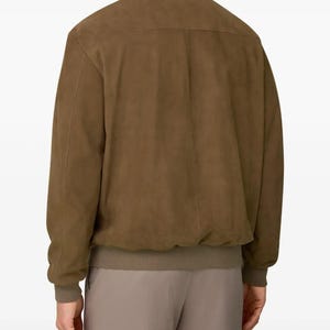 Peut inclure: Veste de bombardier en daim marron avec col montant et poignets et ourlet c&ocirc;tel&eacute;s. La veste a un design classique avec une finition lisse et mate. Le mod&egrave;le porte un pantalon assorti.