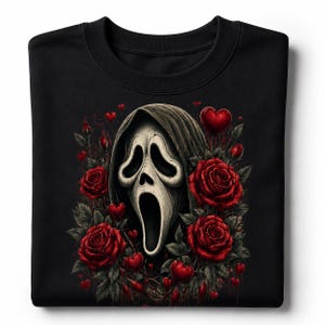 May include: A black crewneck sweatshirt featuring a central graphic of a white, elongated, ghost-like mask with a dark hood, surrounded by deep red roses and small red heart shapes scattered throughout the floral arrangement on the front.