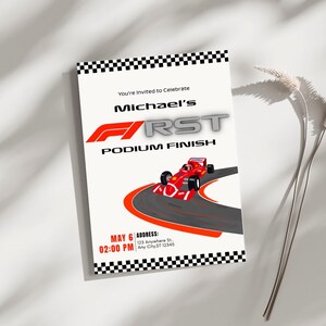 May include: A white invitation card with a black and white chequered border. The card features the text "You're Invited to Celebrate Michael's FIRST PODIUM FINISH" and a red race car graphic. The date and time are also included.