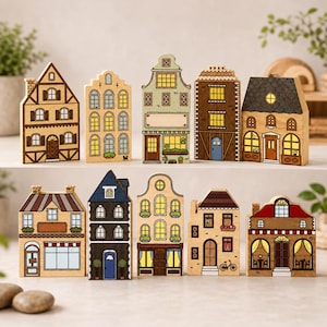 May include: A collection of nine wooden house-shaped blocks, each with unique architectural details. The houses feature various colors, including brown, beige, and blue, with detailed windows, doors, and roof designs. The blocks are arranged on a white surface.