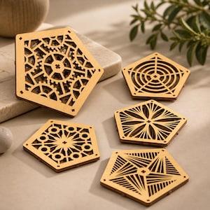 Può includere: Cinque sottobicchieri in legno con intricati disegni geometrici. Uno presenta un motivo a ingranaggi, mentre altri mostrano motivi radiali e lineari. I sottobicchieri sono a forma di pentagono e in legno chiaro.
