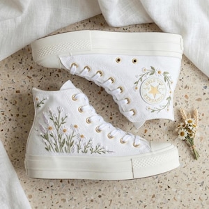 May include: A set of three ceramic mugs with a speckled, matte finish. The mugs are in shades of cream, light gray, and dark gray. Each mug has a simple, minimalist design, perfect for coffee or tea.