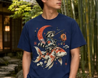 May include: A navy blue short-sleeve t-shirt featuring a graphic illustration of a raccoon wearing a straw hat and traditional clothing, riding a large koi fish. The design includes a red crescent moon, a hanging lantern with the kanji for dream, and Japanese text.