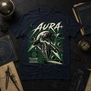May include: A dark navy blue t-shirt featuring a graphic print of an SR-71 Blackbird aircraft flying in front of a moon. The design includes the word AURA in white, a green grid background, smaller planets, and the text SR-71 BLACKBIRD BEYOND THE EDGE.