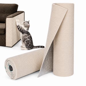 May include: A beige, textured scratching mat for furniture, shown as a rolled-up cylinder with a visible silver-coloured underside. A grey and white tabby cat is shown scratching the same material applied to the side of a brown armchair.