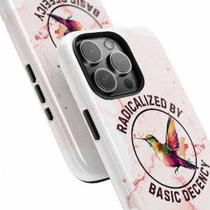 May include: White phone case featuring a watercolour hummingbird design and the text "RADICALIZED BY BASIC DECENCY". The case has a pink marble effect background and a black camera lens frame.