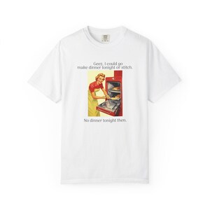 May include: White t-shirt with a vintage-style image of a woman in a red and yellow apron, looking at a red oven. The text on the shirt says: "Geez, I could go make dinner tonight or stitch. No dinner tonight then."